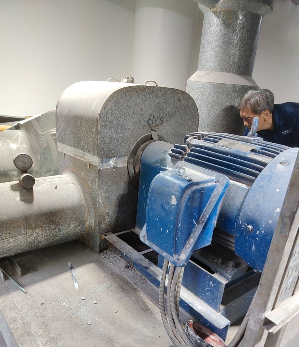 Winsteam engineer inspecting motor-driven plant equipment in a Singapore plant room