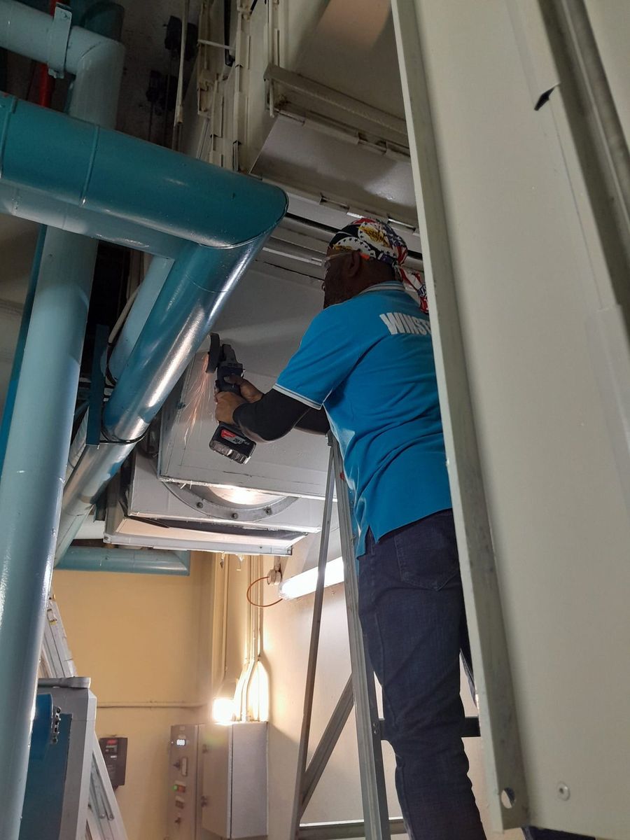 Winsteam Engineering technician servicing an AHU in a Singapore plant room